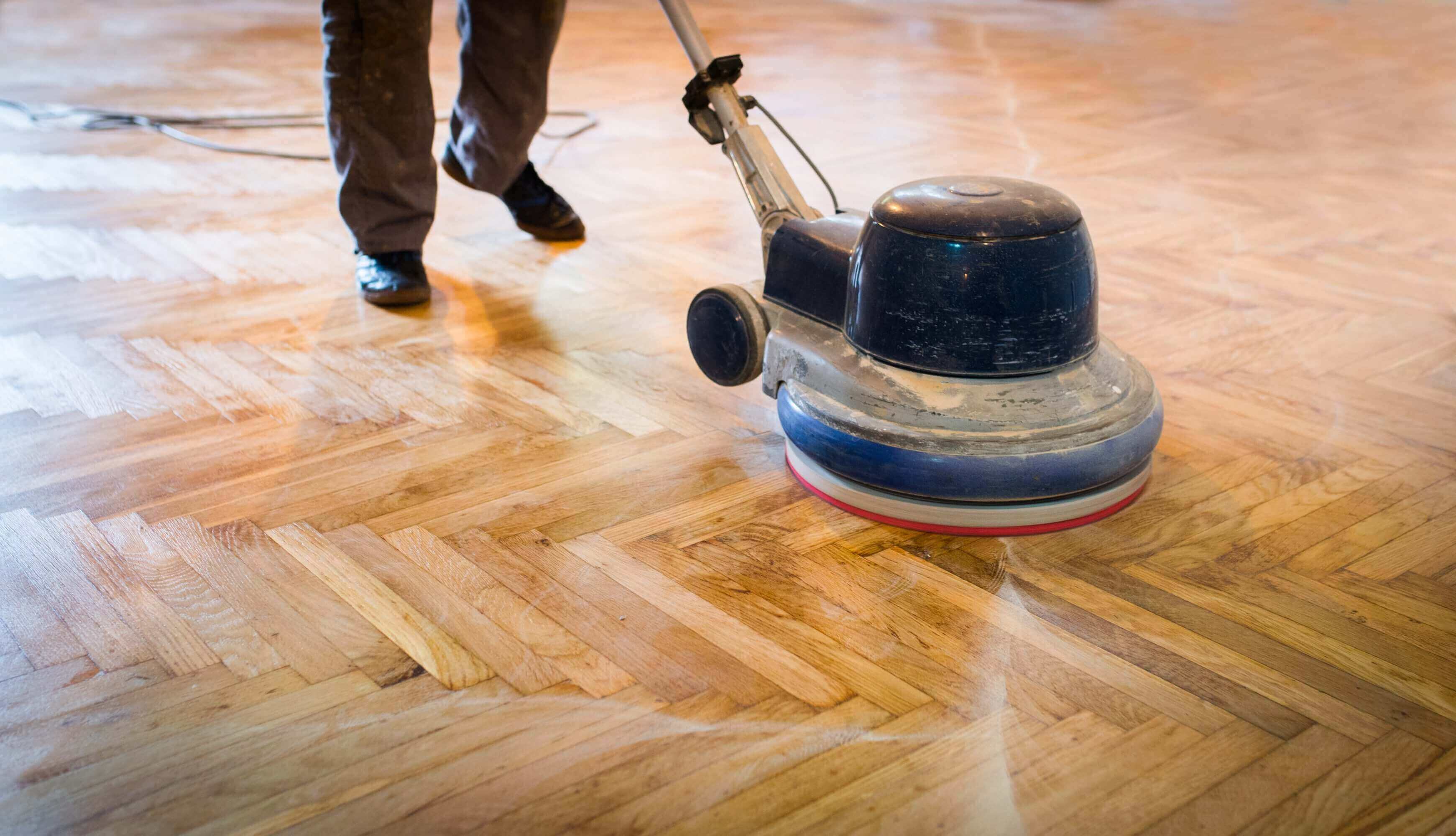 Polishing wooden floor with a machine.
