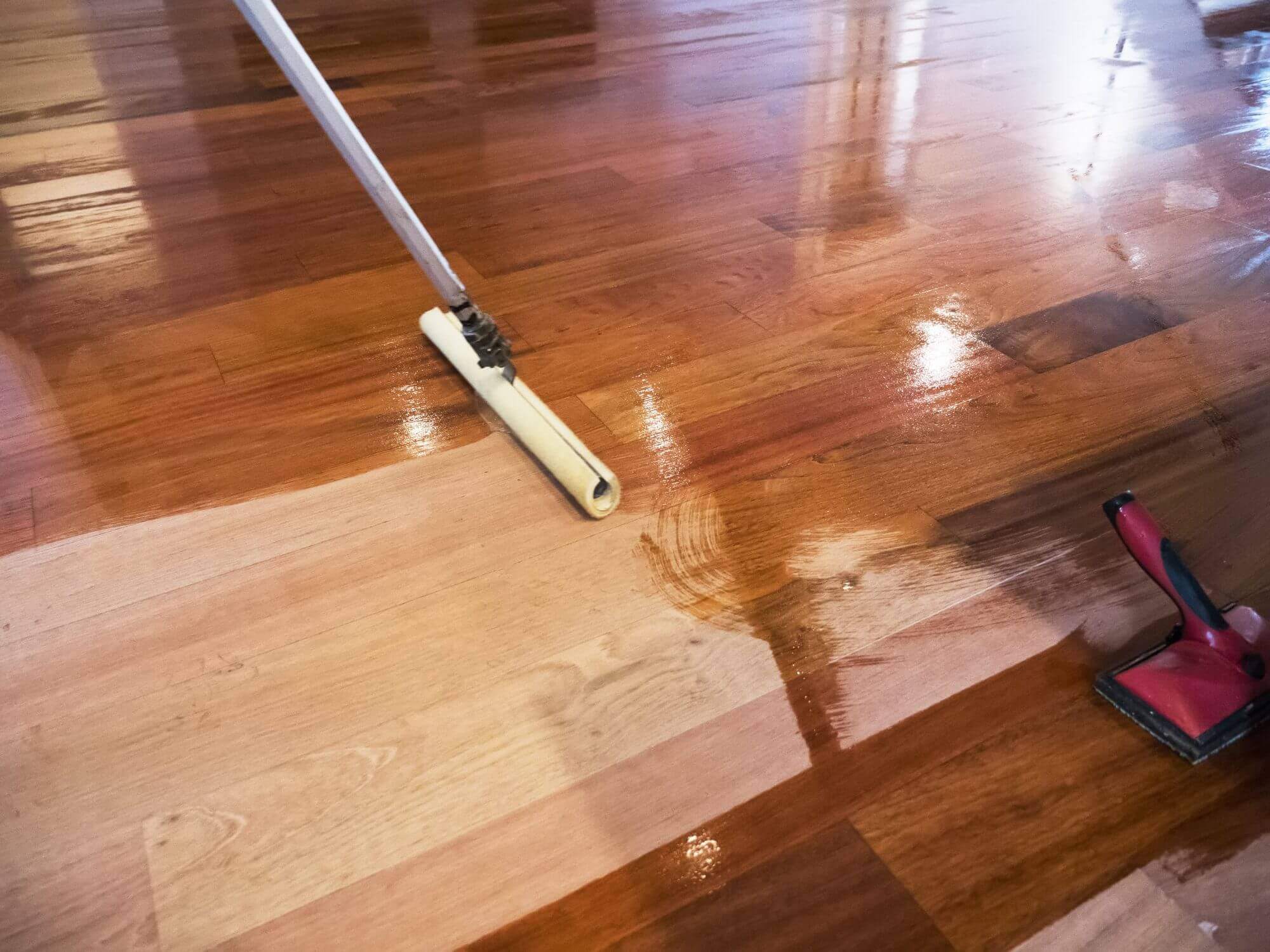 Polishing wooden floor with a mop.